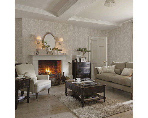 Klassieke woonkamer met open haard, fauteuil, bank en donkere houten meubelen