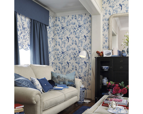 Decoratieve woonkamer met bank, kast, staande lamp en behang met motief