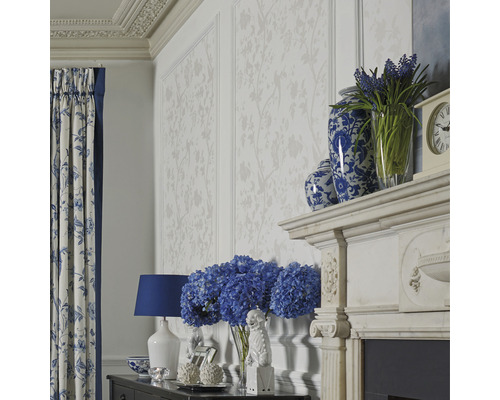 Woonkamer met bloemenbehang, gordijnen met bloemmotief en decoratieve accessoires