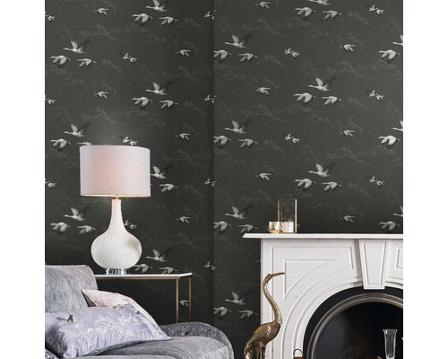 Woonkamer met behang met vogelmotief, lamp, bank en open haard