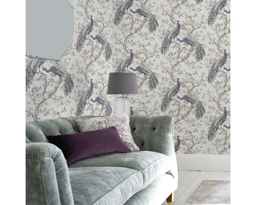 Woonkamer met behang met pauwenmotief, bank en lamp