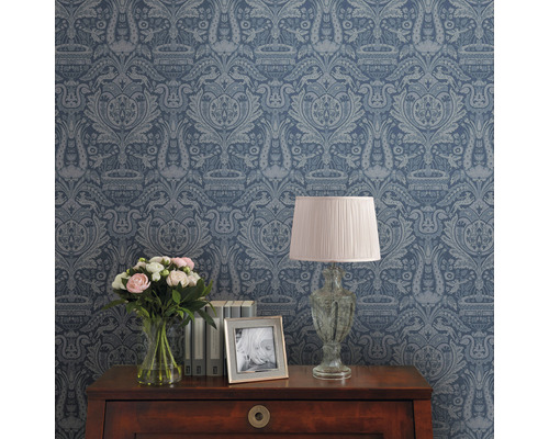 Decoratief behang met patroon op een kamerwand, tafel met lamp, bloemen en fotolijst