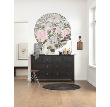 Inrichtingsidee met commode, wanddecoratie, kruk en tapijt in een lichte kamer.