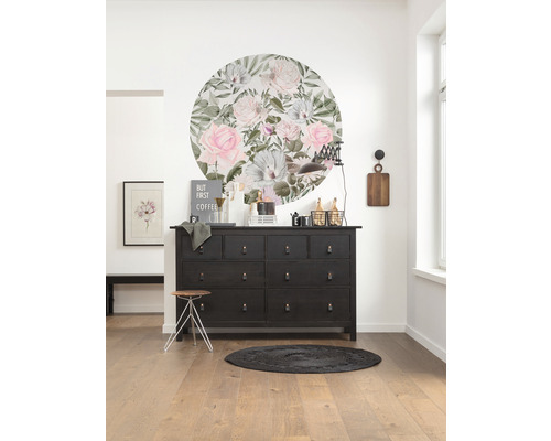 Inrichtingsidee met commode, wanddecoratie, kruk en tapijt in een lichte kamer.