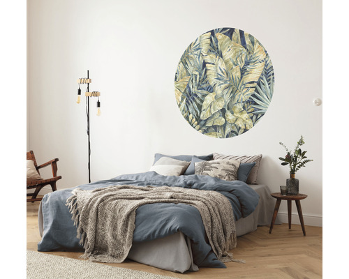 Slaapkamer met tweepersoonsbed, staande lamp en muursticker met bladerenmotief
