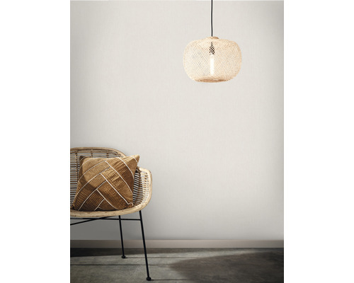 Decoratieve scène met hanglamp van rotan en stoel met kussen