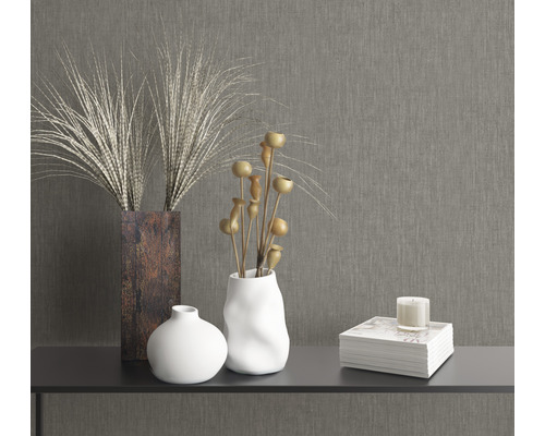 Decoratieve elementen op een tafel: vazen, droogbloemen, boek en kaars.