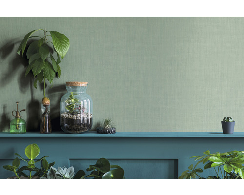 Decoratieve scène met planten, terrarium en plantenspuit op een plank voor een gestructureerde muur