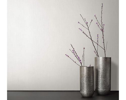 Twee metalen vazen met bloeiende takken voor een muur