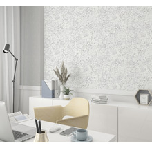 Kantoor met bureau, stoel, lamp en een wand met bloemenbehang