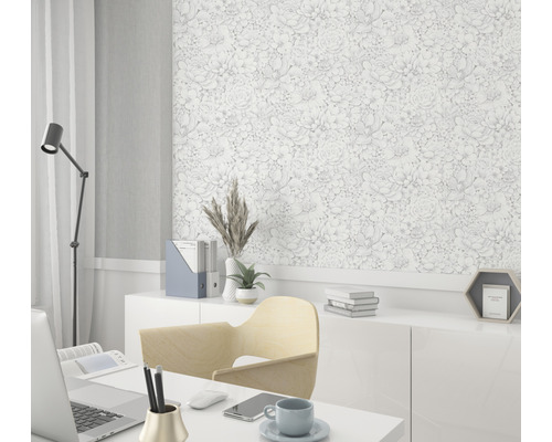 Kantoor met bureau, stoel, lamp en een wand met bloemenbehang