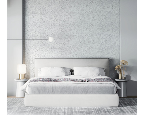 Slaapkamer met bed, nachtkastjes, lampen en bloemenbehang voor een lichte en ruime sfeer.