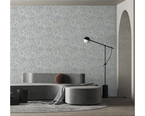 Woonkamer met bloemenbehang, bank, hocker en staande lamp