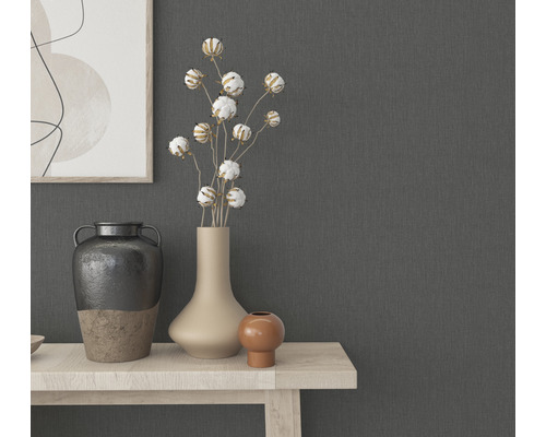 Decoratieve vazen en planten op een lichte houten tafel voor een grijze muur.