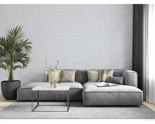 Woonkamer met bank, kussens, tafel, kamerplant en behang met patroon