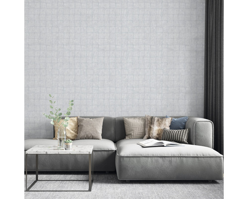 Woonkamer met patroonbehang, bank, kussens en tafel