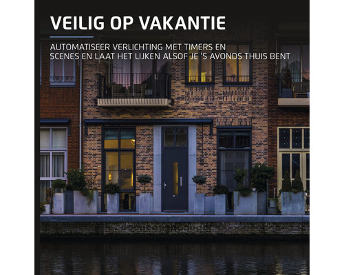 Gevelbeeld van een woning met verlichting geautomatiseerd met timers en scènes om de illusie te wekken dat er ''s avonds iemand thuis is voor de vakantieperiode.