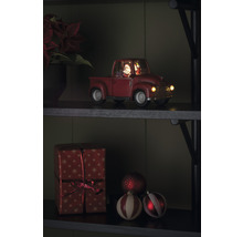 Decoratieve kersttruck met kerstman en cadeau op een plank