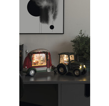 Decoratieve sneeuwbol met kerstman in caravan, getrokken door een tractor