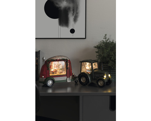 Decoratieve sneeuwbol met kerstman in caravan, getrokken door een tractor