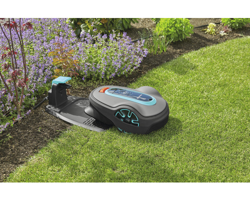 Gardena robotmaaier met laadstation op gazon voor bloembed