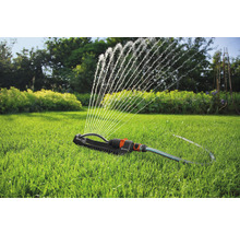 Werkende gazonsproeier op een gazon in de tuin