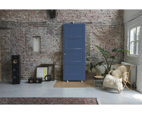 Renovatievoorbeeld met oude deur, luidsprekerboxen en rotan stoel voor een bakstenen muur