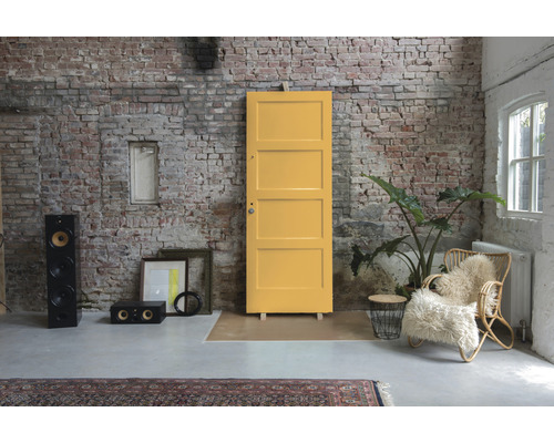 Kameroverzicht met gele deur, luidsprekers, fauteuil en bakstenen muur