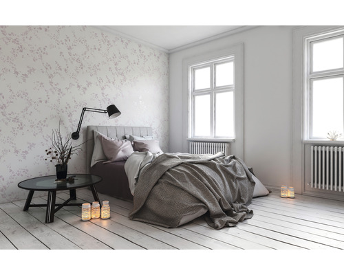 Slaapkamer met bed, nachtkastje en bloemenbehang