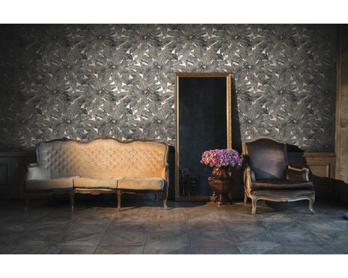 Woonkamer met bank, fauteuil, spiegel en behang met bladerpatroon