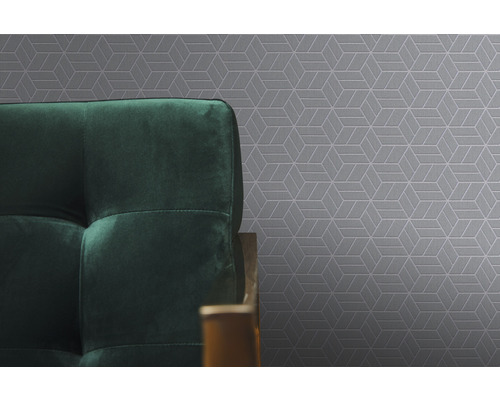 Close-up van grijs behang met geometrisch patroon en een deel van een groene bank