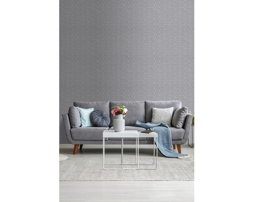 Woonkamer met grijs, patroonbehang, bank, vloerkleed en tafel