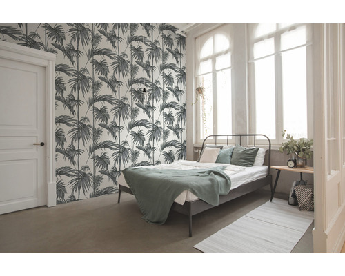 Slaapkamer met bed en palmbladeren behang