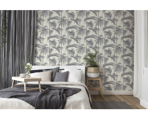 Slaapkamer met bed en behang met palmmotief