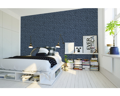 Slaapkamer met bed voor een muurbehang met baksteenmotief