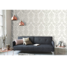Woonkamer met grijze bank en patroonbehang