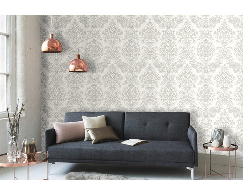 Woonkamer met grijze bank en patroonbehang