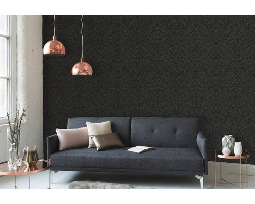 Woonkamer met grijze bank, gedessineerd behang en twee hanglampen