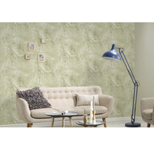 Woonkamer met bank, vloerlamp en behang met plantenmotief