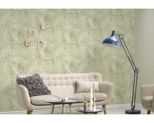 Woonkamer met bank, vloerlamp en behang met plantenmotief