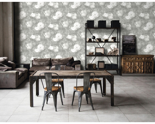 Woonkamer met bloemenbehang, eettafel, stoelen, bank en rek.