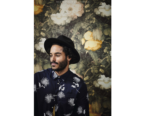Een man met hoed voor een bloementapijt uit de Metropolitan Stories-collectie.