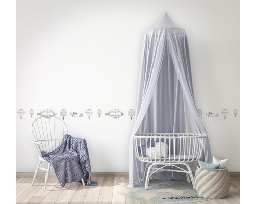 Babykamer met muurrand, hemelbed en stoel met deken