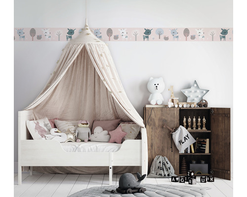 Kinderkamer met hemelbed, wandborder en houten kast met speelgoed