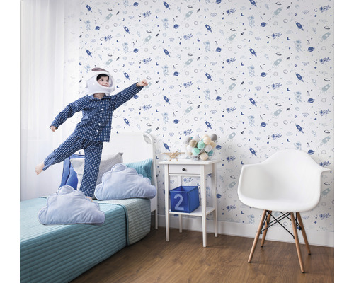 Kinderkamer met ruimtebehang, bed en spelend kind in astronautenkostuum