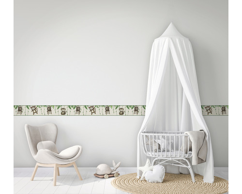 Kinderkamer met rand met apenmotief, wieg en fauteuil