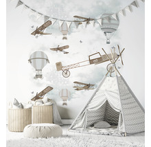 Kinderkamer met muurschildering van vliegtuigen en ballonnen, speeltent en opbergmanden.