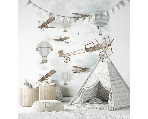 Kinderkamer met muurschildering van vliegtuigen en ballonnen, speeltent en opbergmanden.