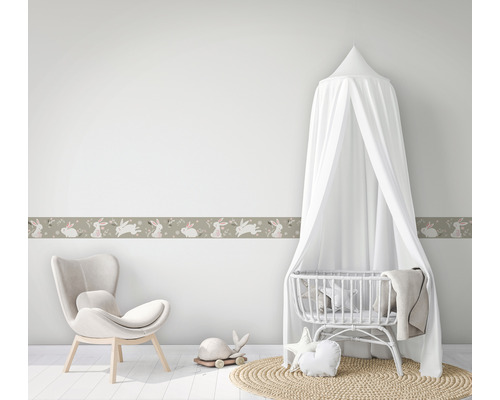 Kinderkamer met behangrand, wieg en fauteuil