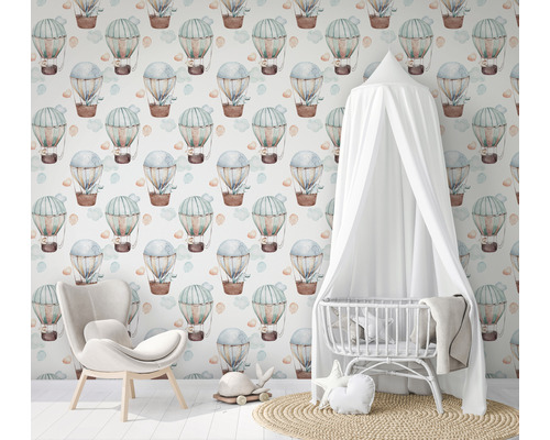 Kamer met wieg, fauteuil en behang met luchtballonnen